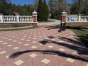 Gated entryway featuring a decorative paved driveway and ornate columns, enhancing the property's curb appeal at 27826 Robin Roost Ln, Wesley Chapel, FL 33544