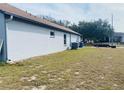 Exterior view of the home showcasing the side yard and an air conditioning unit at 4209 Amber Ridge Ln, Valrico, FL 33594