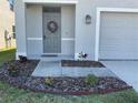 Charming front door with a welcoming wreath and well-maintained landscaping adds curb appeal at 16949 Secret Meadow Dr, Odessa, FL 33556