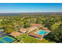 Aerial view of the community center featuring a swimming pool, tennis court, and surrounding green spaces at 2300 Shelly Dr # C, Palm Harbor, FL 34684