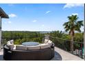 An outdoor living area with comfortable lounge seating provides peaceful views of the water and tree line at 4902 Carranza Ct, Tampa, FL 33616