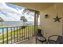 Inviting balcony with seating offers serene views of the pool, dock, and sparkling waters at 7520 Sunshine Skyway S Ln # T18, St Petersburg, FL 33711