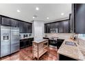 Well-equipped kitchen features stainless steel appliances, dark cabinetry, and granite countertops at 10409 Waterstone Dr, Riverview, FL 33578