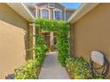View of an arched, greenery-covered entrance leading into the home's front door at 18827 Duquesne Dr, Tampa, FL 33647