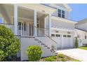 Charming home with covered front porch, stairs leading to the entrance, and a two-car garage at 323 Appian Ne Way, St Petersburg, FL 33704