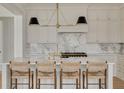 Modern kitchen island with marble countertop, seating, and stylish pendant lighting at 323 Appian Ne Way, St Petersburg, FL 33704