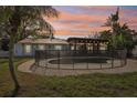Private backyard oasis featuring a fenced pool and a covered patio for entertaining, all surrounded by tropical greenery at 4829 W San Miguel St, Tampa, FL 33629