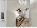 Bright foyer with high ceilings, decorated console table, tile flooring, and a white front door at 17102 Yellow Pine St, Wimauma, FL 33598