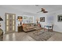 Bright living room featuring neutral paint, large windows, ceiling fan, tile floors, and comfortable seating arrangement at 1742 Mississippi Ne Ave, St Petersburg, FL 33703