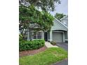 Well-kept one-story home with a gray garage, lush landscaping, and a welcoming entrance at 3653 Kings Rd # 101, Palm Harbor, FL 34685