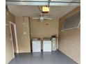 Interior of a well-lit garage equipped with a washer, dryer, and water heater at 3653 Kings Rd # 101, Palm Harbor, FL 34685
