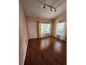 Bright living room featuring wood floors, a front door, and windows with sheer white curtains at 3653 Kings Rd # 101, Palm Harbor, FL 34685