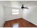 Bedroom with hardwood floors, a ceiling fan, and a window for natural light at 4242 Redcliff Pl # C, New Port Richey, FL 34652
