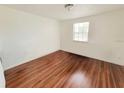 Bedroom with hardwood floors and a window for natural light at 4242 Redcliff Pl # C, New Port Richey, FL 34652