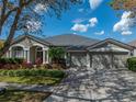 Charming single-story house with mature landscaping, three-car garage, and inviting entrance at 6307 Bridgevista Dr, Lithia, FL 33547