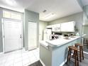 Cozy kitchen featuring white cabinets, a breakfast bar with seating, and tile flooring at 2116 Nantucket Dr # 19, Sun City Center, FL 33573