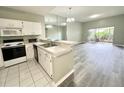 Bright kitchen featuring white cabinetry, a breakfast bar, appliances, and an open view to the living area at 2116 Nantucket Dr # 19, Sun City Center, FL 33573