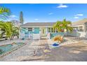 Charming coastal home featuring a fenced yard, white picket fence, palm trees and decorative stone landscaping at 421 77Th Ave, St Pete Beach, FL 33706