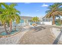 Charming coastal home featuring a fenced yard, white picket fence, palm trees and decorative stone landscaping at 421 77Th Ave, St Pete Beach, FL 33706