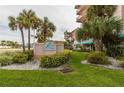 Exterior daytime shot of The Beach Cottage with lush landscaping and beautiful signage at 18400 Gulf Blvd # 1505, Indian Shores, FL 33785