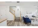 Bright living room featuring hardwood flooring, staircase, modern furniture, and neutral paint, creating a welcoming atmosphere at 2794 Countryside Blvd # 1, Clearwater, FL 33761