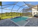 Sparkling pool within a screened enclosure, features tiled steps and a tranquil view of the lush surroundings at 14215 Swiss Bridge Dr, Riverview, FL 33579