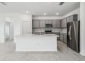 Open kitchen featuring grey cabinets, stainless steel appliances, a large island, and tile flooring at 4306 Big Sky Dr, Spring Hill, FL 34604