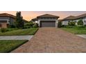 A brick driveway leads to a home with a two car garage and manicured front lawn at 11125 Callisia Dr, Odessa, FL 33556