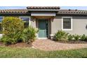 Inviting front entrance with a stylish teal door, brick walkway, and lush landscaping at 11125 Callisia Dr, Odessa, FL 33556