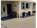 Close-up of the home entrance with a cozy bench, decorative planters, and a colorful welcome mat at 322 S Port Royal Ln, Apollo Beach, FL 33572