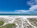 Beautiful beach featuring white sand and crystal-clear water under a blue sky with fluffy clouds at 3910 Gulf Blvd # 400, St Pete Beach, FL 33706