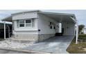 Well-maintained mobile home featuring white siding, a covered carport, and an extra storage area at 5335 Fairfield S Ave # 78, Gulfport, FL 33707