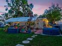 Inviting backyard featuring a covered patio, hot tub, string lights, and lush green lawn perfect for outdoor enjoyment at 6145 55Th N Ave, St Petersburg, FL 33709