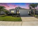 Charming single-Gathering home featuring lush landscaping, a two-car garage, and a cozy front porch at 12425 Glenridge Ln, Parrish, FL 34219