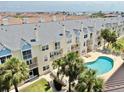 Beautiful condo exterior featuring a shared pool, balconies, and tropical landscaping at 443 Pinellas Bayway S # 105, Tierra Verde, FL 33715