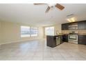 Open concept kitchen with dark cabinets, stainless steel appliances, granite counters, and tile flooring at 10118 Hickory Hill, Port Richey, FL 34668