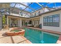 Stunning backyard with a large pool, a hot tub, and an outdoor kitchen at 1903 Haven Bend, Tampa, FL 33613