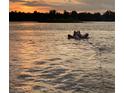 Tranquil sunset lake view featuring people on a float in the water at 1903 Haven Bend, Tampa, FL 33613
