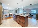 An open concept kitchen boasts an island, stainless steel appliances, and a clear view into the dining and living room at 2446 Belleair Rd, Clearwater, FL 33764