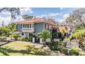 Beautiful two-story home with a tile roof, balcony, manicured landscaping, a black iron gate, and a lush yard at 7922 Flowerfield Dr, Tampa, FL 33615