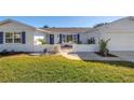 Charming single Gathering home featuring a lush front lawn, a beautiful garden, palm trees and two-car garage at 8418 Flagstone Dr, Tampa, FL 33615