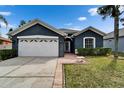 Charming single-story home featuring an attached two-car garage, and a well-manicured lawn at 10322 Goldenbrook Way, Tampa, FL 33647