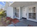 Close-up of a light blue home with a white front door, shutters, and landscaped front at 16211 Rambling Vine W Dr, Tampa, FL 33624