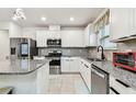 Bright kitchen featuring granite countertops, stainless steel appliances, and white cabinetry at 6684 Devlin Ln, Wesley Chapel, FL 33545