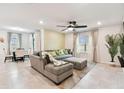 Open-concept living room showcasing a large sectional sofa, ceiling fan, and natural light at 6684 Devlin Ln, Wesley Chapel, FL 33545