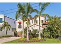 Landscaped Mediterranean-style home with a garden, a brick driveway, and a two-car garage at 801 Brightwaters Ne Blvd, St Petersburg, FL 33704