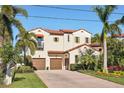 Mediterranean-style home with a brick driveway, two-car garage, and mature landscaping at 801 Brightwaters Ne Blvd, St Petersburg, FL 33704