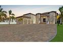 Expansive home featuring a tile roof, portico entry, three-car garage and large brick driveway at 9401 93Rd St, Seminole, FL 33777