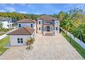 Stunning two-story home featuring a tile roof, arched windows, and a large paved driveway with mature landscaping at 9401 93Rd St, Seminole, FL 33777