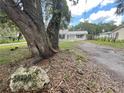 Residential home's exterior view showcases mature trees and the house number on a stone at 34799 Evergreen Way, Dade City, FL 33523